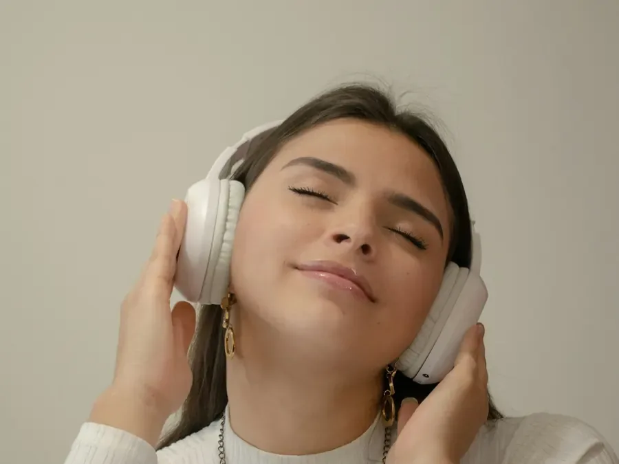 Mulher de olhos fechados ouvindo uma auto-hipnose com fones