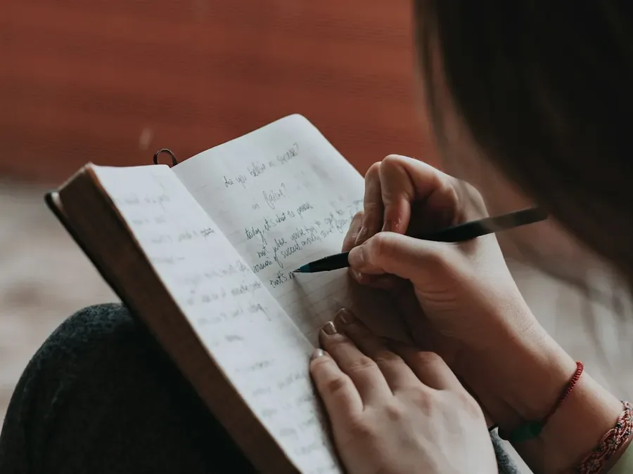 Mão escrevendo num caderno