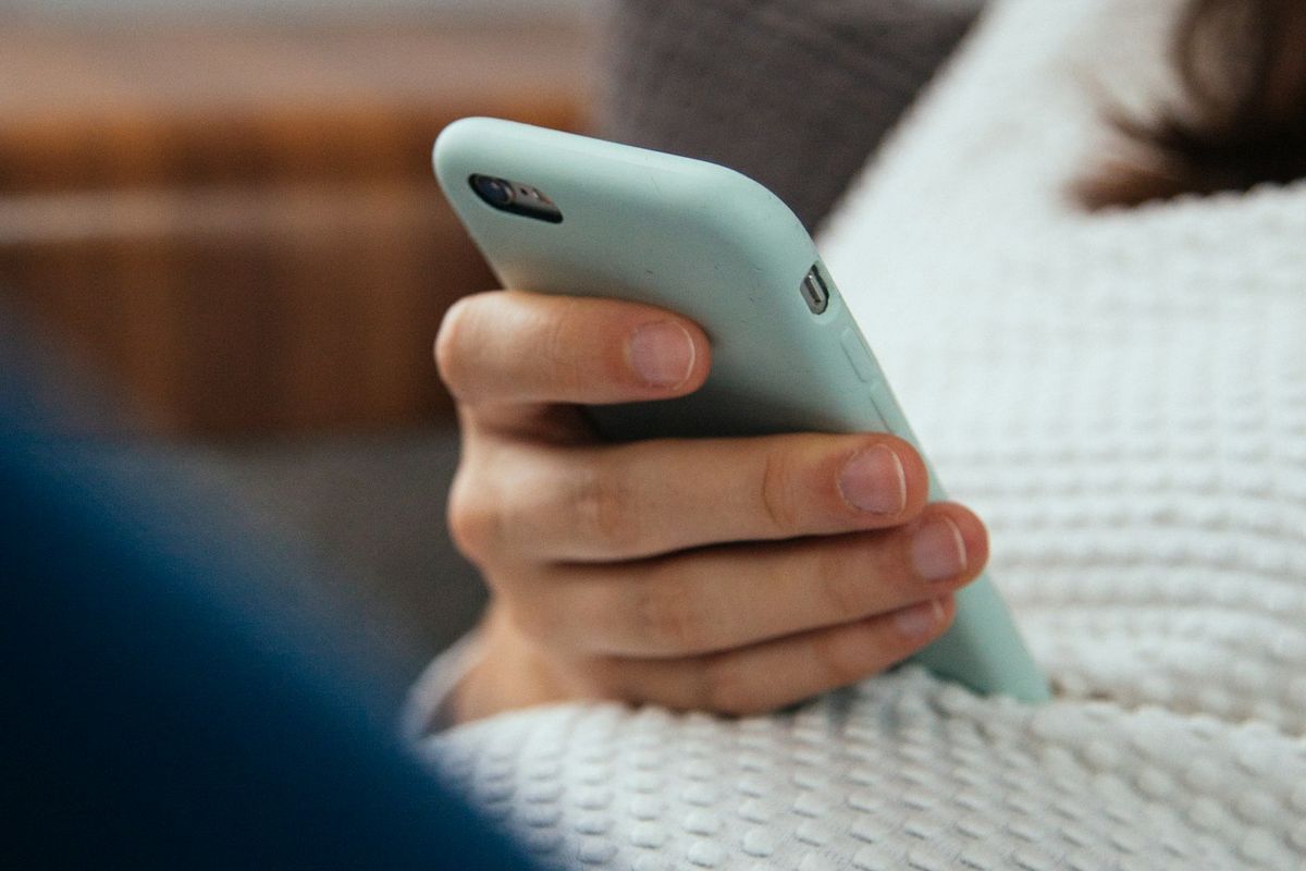 Mão segurando o celular: distrações imediatas alimentam a procrastinação